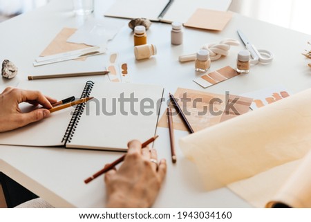 An artist or a designer in the process of sketching in the artist’s workspace. Creativity and design concept.