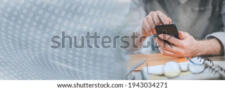 Male hands using mobile phone; panoramic banner