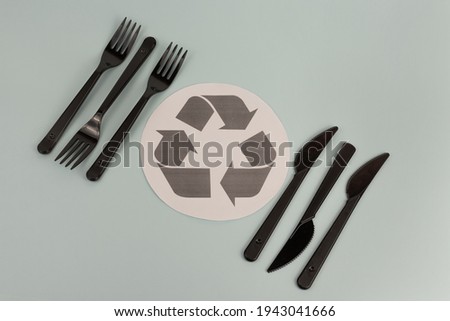 disposable knives and forks. recycling sign in the center