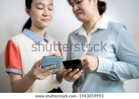 Asian adult woman smirk smile with disdain on her face shows scornful abuse,dissatisfied teenage lady girl with disrespect expressing contempt,envy others,disgust as he reads a message on mobile phone Royalty-Free Stock Photo #1943059993