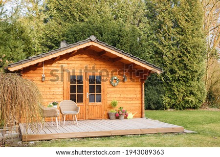 Wooden garden shed with terrace. Wooden garden shed. Life in the country in Germany in summer. Vacation in the country.  Royalty-Free Stock Photo #1943089363