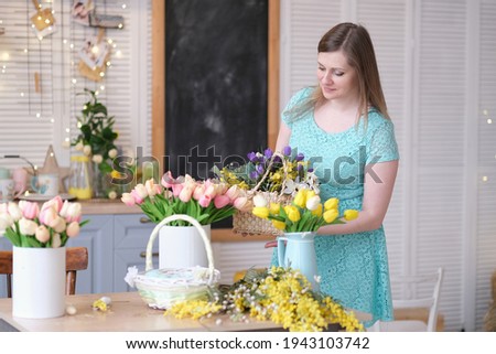 woman decorates her house with flowers. woman collects a bouquet at home in the kitchen. spring mood