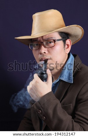 Smoking a pipe. Portrait of handsome young man in hat smoking a pipe
