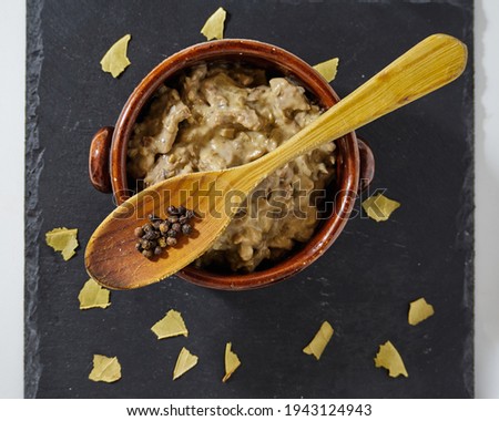 Beef stroganoff in a clay bowl decorated with bay leaves and a spoon. Top View
