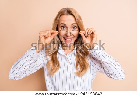 Photo of nice impressed mature lady wear striped shirt arms spectacles isolated beige color background