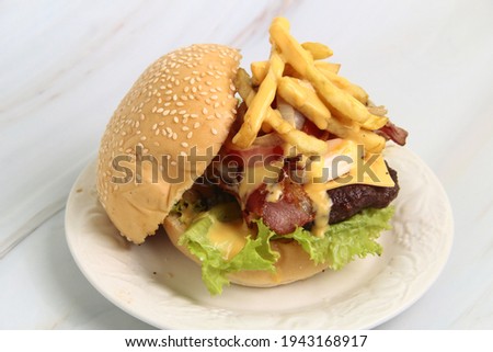 Photo of freshly made giant hamburger sandwich with cheese and vegetables.