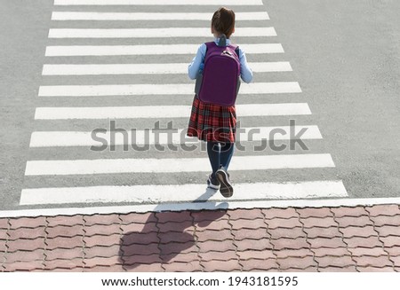 Stylish young teen girl walking with backpack. Active child. Kid runs across the crosswalk. Way forward. Direction to success. Positive thinking. Symbol of overcome obstacles and challenge. Top view