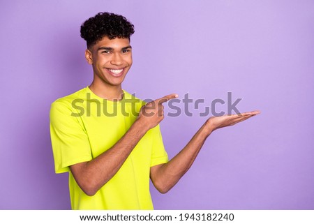 Photo of young handsome happy cheerful smiling demonstrate advertise product isolated on purple color background