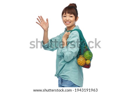 happy asian woman with food in reusable string bag