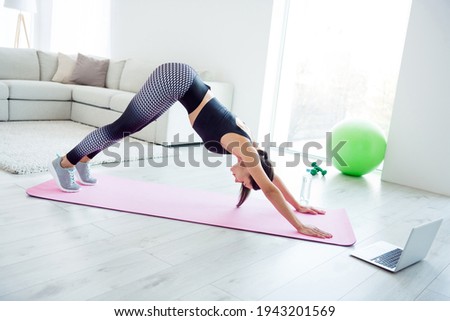 Full length profile side photo of young attractive woman training yoga stretching fitness sporty indoors