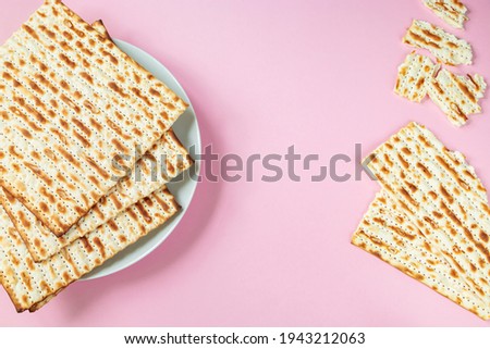 Matzo on pink background. Traditional Jewish food
  for regilious spring holiday of Pesach. Happy Passover. Copy space.