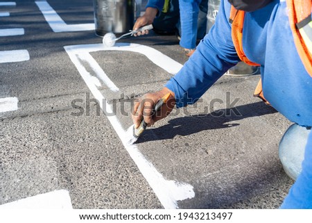 Two workmen are making the traffic signs for the street.