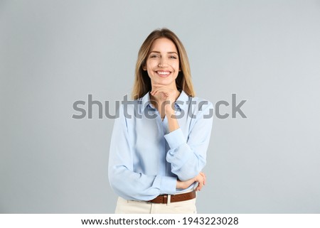 Portrait of beautiful young businesswoman on light grey background