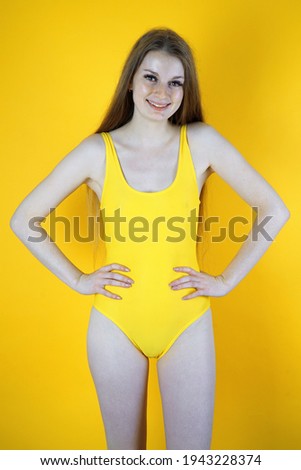 Teenage girl posing in yellow swimsuit in studio                            