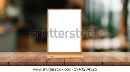 Menu with isolated white on wooden table on blurred restaurant background.