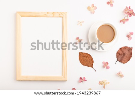 Composition with wooden frame, brown beech autumn leaves, hydrangea flowers and cup of coffee. mockup on white background. Blank, flat lay, top view, still life, copy space.