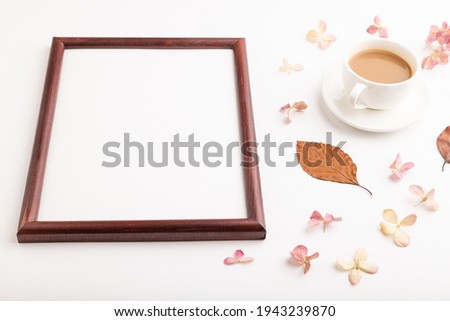 Composition with wooden frame, brown beech autumn leaves, hydrangea flowers and cup of coffee. mockup on white background. Blank, side view, still life, copy space.