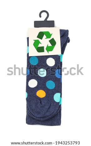 Colorful socks with recycling label on white background, top view