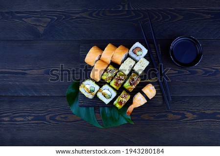 Sushi set on the black background. Sushi roll Philadelphia with salmon and cream cheese. Sushi roll Maki with eel, avocado. 