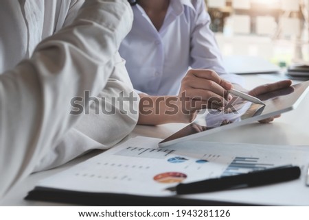 Businessman and business woman discuss to working with using tablet and for searching information stock market chart for trading to Make a profit. Planning and Investment concept.