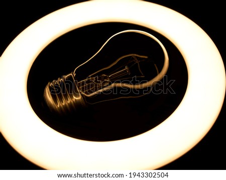 Lamp night light in a dark background. Vintage effect style picture. ring lamp. Incandescent lamp inside LED ring light source Concept photography, the light takes the form of an incandescent lamp
