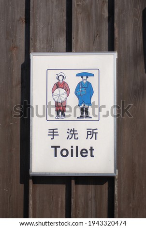 Funny Japanese toilet sign with red and blue logo.