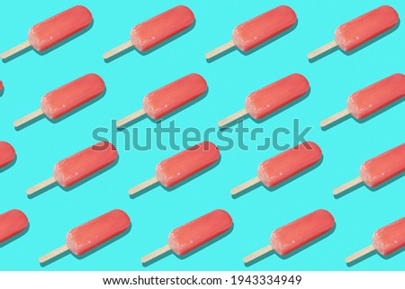 Red ice cream popsicles on blue background. Seamless texture or pattern (flip image)