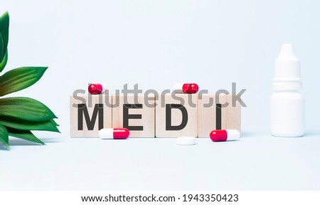 MEDI. Text abbreviation on wood cubes blocks on light blue background. Most commonly diagnosed mental disorder of children. Close up.