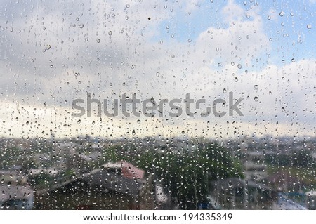 Drops on window with blur cityscape a background