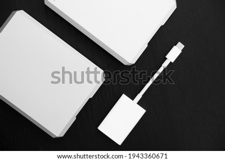 External storage media. Modern usb-c connectors. Two external hard drives in silver and a white card reader with a type-c connector. Storage, copying and backup of data for photographers