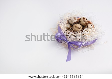 quail eggs in paper filling, tied with a purple satin ribbon on a white background with a place for the signature