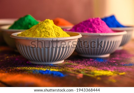top view of colorful traditional holi powder in bowls isolated on dark background.Space for text . happy holi.Concept Indian color festival called Holi Royalty-Free Stock Photo #1943368444