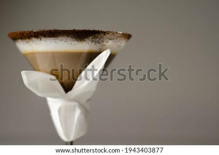Coffee cocktail with a nutty note with fluffy milk foam, decorated with shavings of chocolate, served with an Easter bunny-shaped napkin, sweet drink