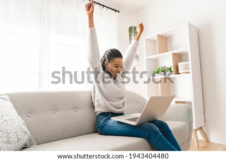 A portrait of a beautiful young woman smiling with laptop and hand high