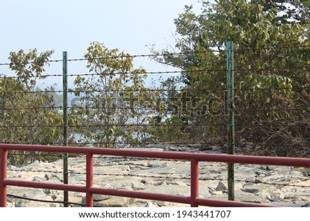 Metal made barbed fence wire barrier or boundary display with cropped view.