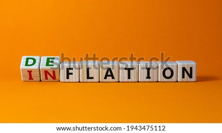 Inflation or deflation symbol. Turned cubes and changed the word inflation to deflation. Beautiful orange background, copy space. Business, inflation or deflation concept. Royalty-Free Stock Photo #1943475112