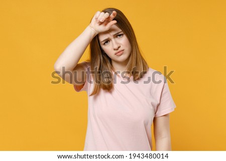 Young sick ill tired caucasian exhausted woman 20s wearing casual basic pastel pink t-shirt looking camera put hand on forehead having headache isolated on yellow color background studio portrait Royalty-Free Stock Photo #1943480014