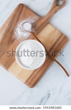 White powder in bowl with wooden spoon Royalty-Free Stock Photo #1943481685