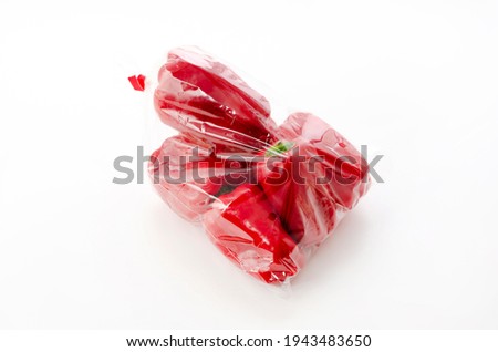 Red bell pepper in plastic bag on white background