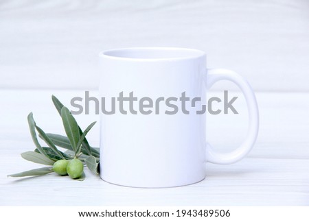 White ceramic mug with olive branch.on White background.  11oz mug mock up Royalty-Free Stock Photo #1943489506