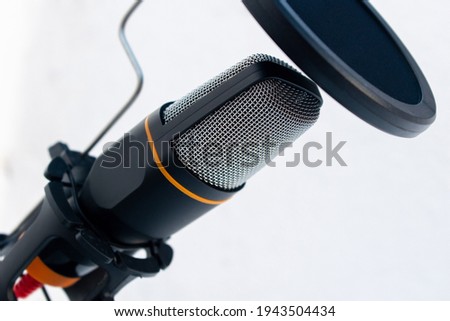 A closeup of a black and grey microphone captured on a white background