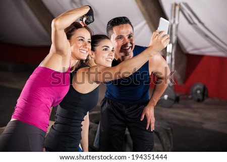 Strong and athletic Hispanic people taking a fun group selfie at a gym