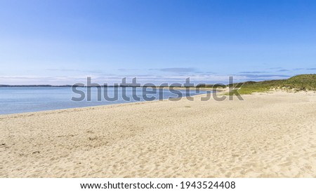 An empty calm white sand beach under the clear blue sky