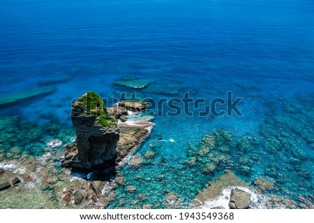 High cliff view of a pinnacle rock in a stunning crystalline shiny turquoise sea. Yonaguni Island. Royalty-Free Stock Photo #1943549368