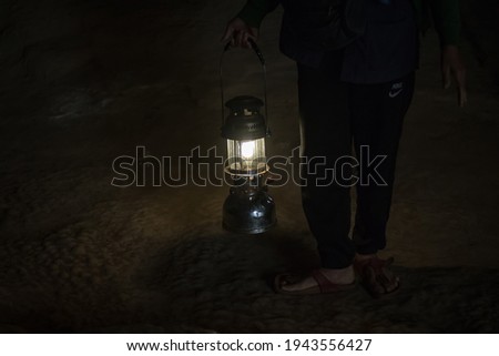 A man with a lamp in the dark, in cave