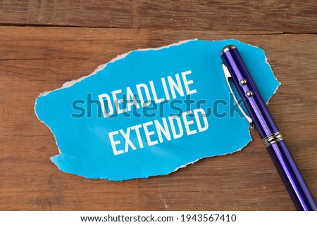 Top view of pen and torn paper written with DEADLINE EXTENDED. Royalty-Free Stock Photo #1943567410