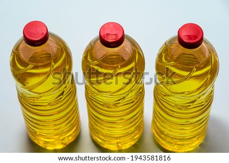 Bottles of edible soy oil on blue background. Olive oil for salads and cooking in general. Soybean oil is extracted from soybean seed and is used as a food source and as biofuel.