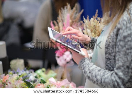 young woman entrepreneur takes pictures of his hand-made floral composition for the blog. the concept of promoting an entrepreneur on the internet.