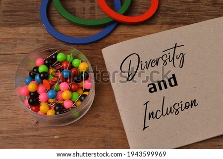 Top view of pinboards, wooden shape and memo note written with DIVERSITY AND INCLUSION