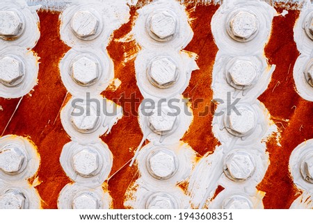 abstract background of bolts and nuts painted white on a red background